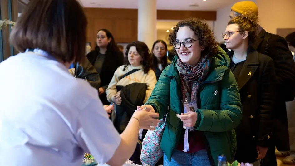 Eine junge Frau erhält ein Teilnahmeschild von einer ZWST Mitarbeiterin