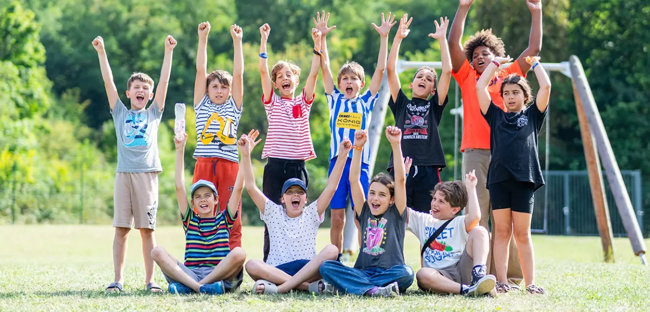 Eine Gruppe Kinder mit erhobenen Armen lacht