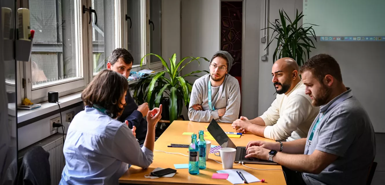 Gruppe junger Erwachsener arbeitet am Tisch