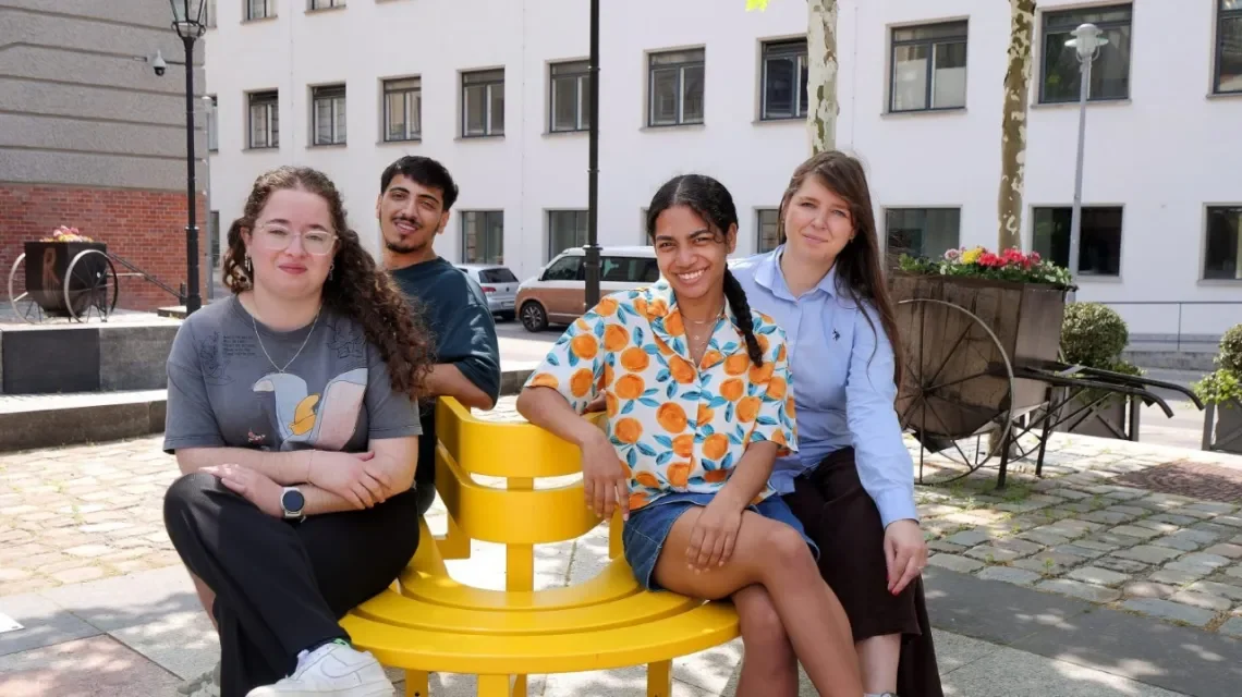 Vier junge Menschen sitzen draußen